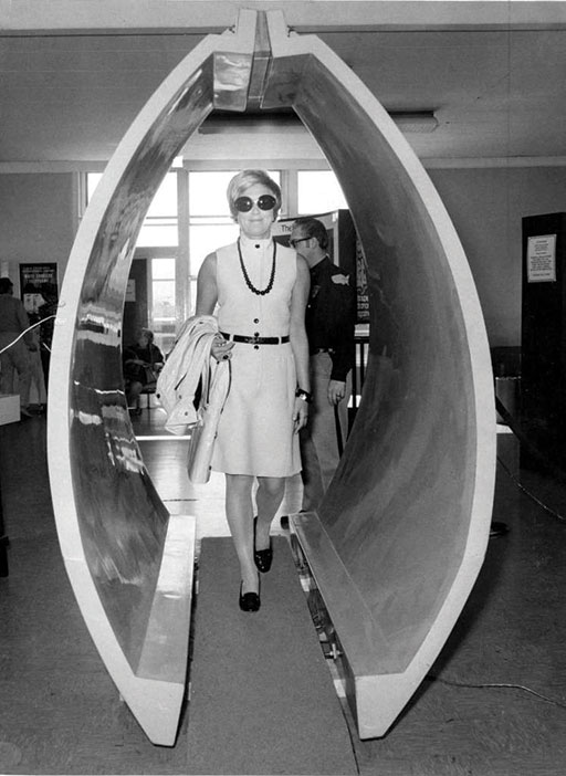 A woman walking through a metal detector at  San Francisco International Airport in 1973  (Credit: Bill Young)