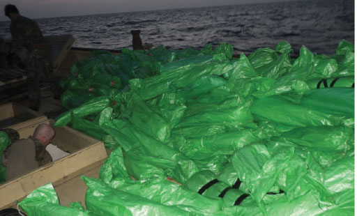 Plastic-wrapped weapons are seen on the deck of a stateless dhow that the U.S. Navy said carried a hidden arms shipment in the Arabian Sea on Friday, May 7, 2021. The U.S. Navy announced Sunday it seized the arms shipment hidden aboard the vessel in the Arabian Sea, the latest-such interdiction by sailors amid the long-running war in Yemen. (U.S. Navy)