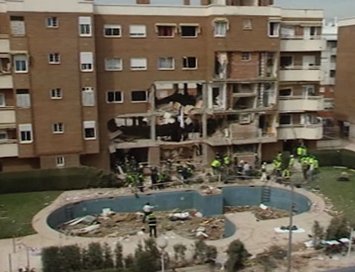 As law enforcement closed in on the terrorist group in this apartment building, the terrorists detonated a bomb that used the same explosives that had been used in the train bombings. GEO Agent, Javier Torronteras, did not survive the blast. The remains of seven terrorists were recovered from the rubble. Still from video from 11M documentary.