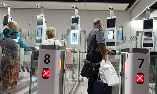 London, UK - April 15, 2018: Air travelers pass through automated passport border control gates at Heathrow Airport.