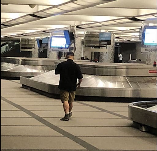 An individual with no baggage, coming in from the exit and taking pictures of baggage or equipment raised concern among passengers.